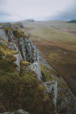 İngiltere 'de bulutlu bir günde Hadrians Duvarı boyunca sarsıcı uçurumlar..
