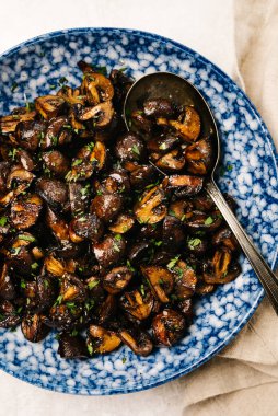 Bir kase terbiye edilmiş ve kızartılmış Cremini mantarın tepeden çekilmiş fotoğrafı.