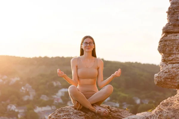 Young Woman Meditates Rock Sunset Alone Herself — Zdjęcie stockowe