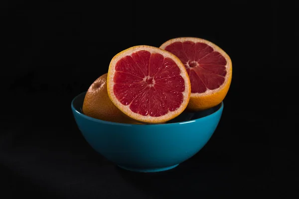 Pomelo Rojo Tazón Azul Sobre Fondo Negro —  Fotos de Stock