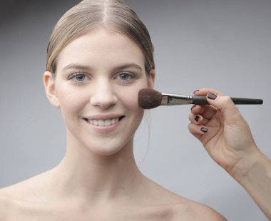 Makyaj arasında güzel bir genç kadının portresi var.