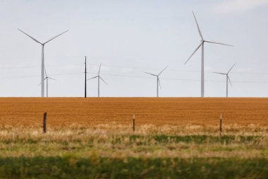 Rüzgar türbinleri Batı Teksas 'taki çiftliklerin yakınında elektrik üretir..