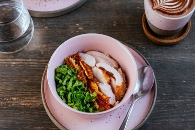 Tavuklu pilav, ahşap masadaki kasede otlar.