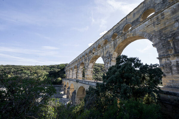 Pond du Gard roman aqueduct, with sunlight and blue sky, close view