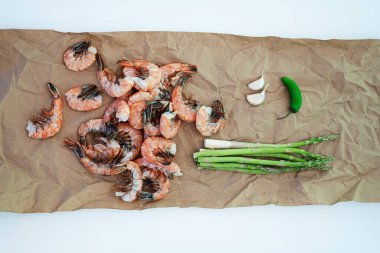 Kağıt sofra takımında çiğ karides kuşkonmaz ve jalapeno.