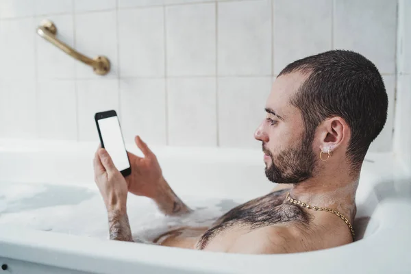 Білий Чоловік Розслабляється Ванній Дивиться Білий Екран Мобільного Телефону — стокове фото