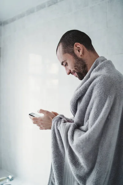 Hombre Blanco Feliz Con Una Toalla Está Mirando Teléfono Baño — Foto de Stock