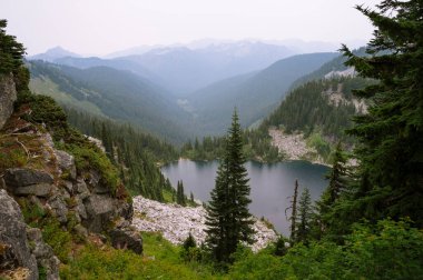 Pct boyunca ağaçlar ve granit kayalarla çevrili Alp Gölü.