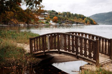 Autumn wooden bridge over a serene river
