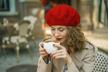 Kırmızı bereli kadın kahve içiyor. Paris Kafe yaşam tarzı.