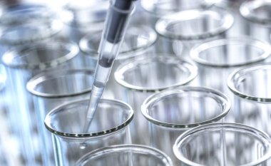 Bir laboratuvar deneyi sırasında bilim adamı pipet örneği alıyor.