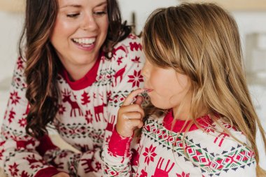 Anne ve kızı süsleme yaparken krema tadarlar.