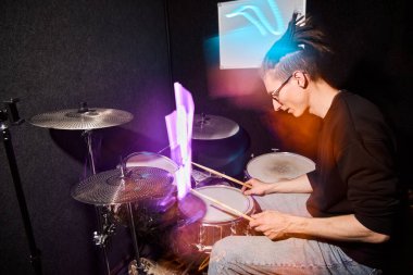 Canlı ışıklandırma efektleri olan bir stüdyoda davulcu.