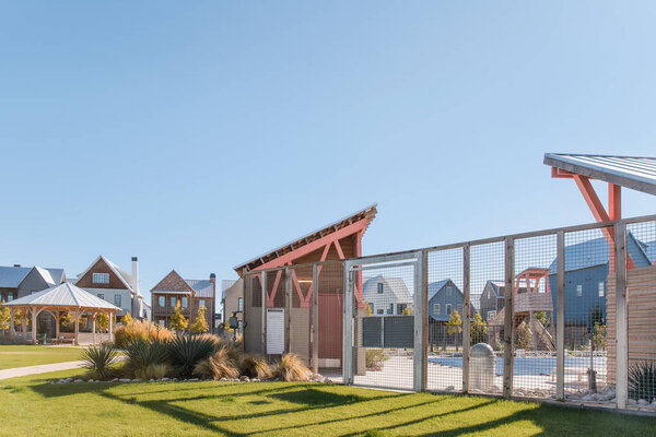 Fenced community pool area with modern structures in suburban setting.