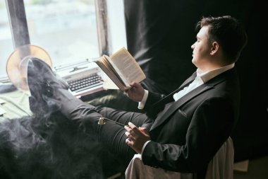 Duman ve daktilo ile takım elbise kitap okuyan adam