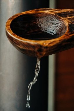 Bir İsveç saunasına su döken tahta bir sauna kaşığını kapat.