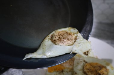 Kavrulmuş yumurta ve biber tavadan kayıyor.