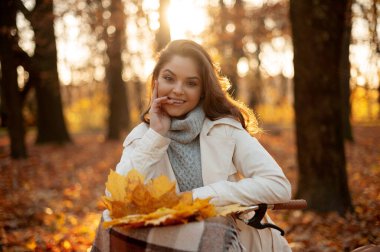 Ormanda bisikletli bir kadın kameraya gülümsüyor.