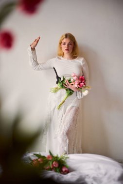 Model zarif pozlar verir. Kapalı alanda yumuşak güneş ışığı altında çiçekler.