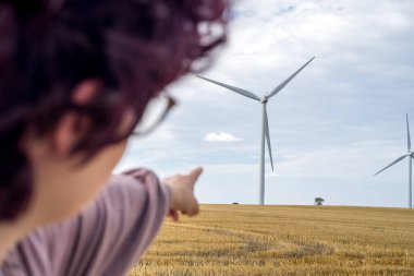 Genç kız ve yel değirmenleri gelecek ve yeşil enerji konsepti