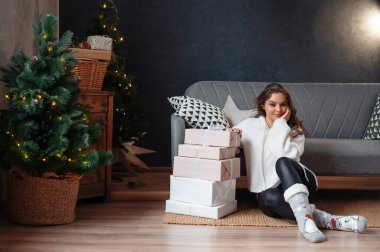 Noel 'den sonraki sabah hediyelerle poz veren genç bir kadın.