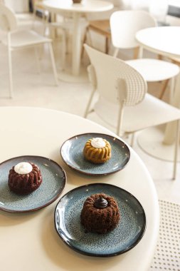 Kafe masasında kremalı mini kekler