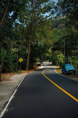 Senggigi, Lombok yakınlarında bekleyen Blue Taxi ile Curving Forest Road