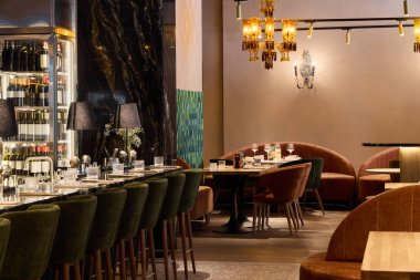 Konforlu koltukları ve sıcak ışıklandırması olan şık bir restoran.