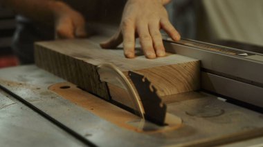 Yetenekli bir zanaatkar çiğ tahta kesmek için testere kullanır.