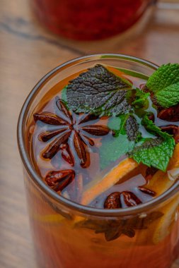 Baharatlı sonbahar çayı ve şeffaf bardakta nane.
