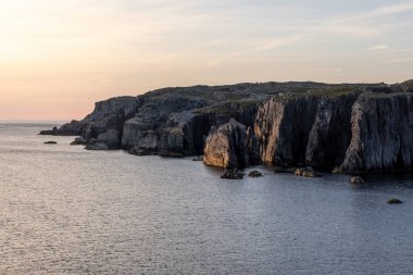 Deniz kıyısındaki engebeli uçurumlarda gün doğumu