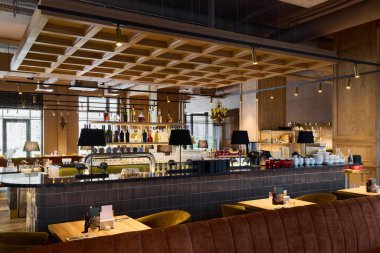 Sıcak ışıklandırması olan modern bir restoranın içi.