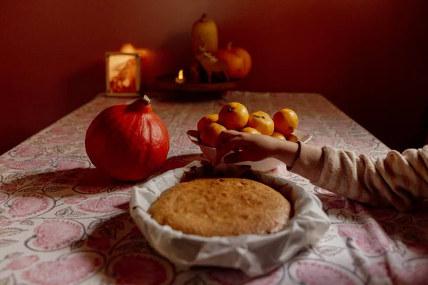 Çocuk desenli masa örtüsünde ev yapımı pasta kesiyor.