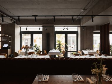 Doğal ışığı olan modern bir restoranda şık bir yemek salonu.