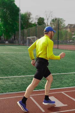 Koşucu futbol sahasının yakınında koşuyor