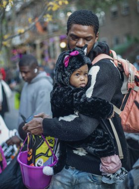 Cadılar Bayramı geçit töreninde siyah bir baba ve çocuk.