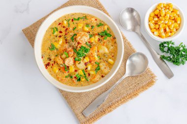 Taze karides, mısır ve patatesle yapılan kremalı deniz ürünleri çorbası.