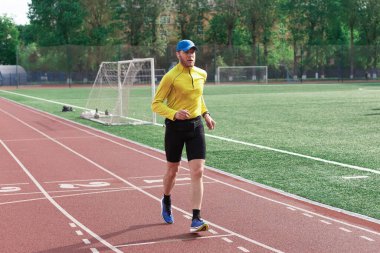 Koşucu stadyumda gol atıyor.