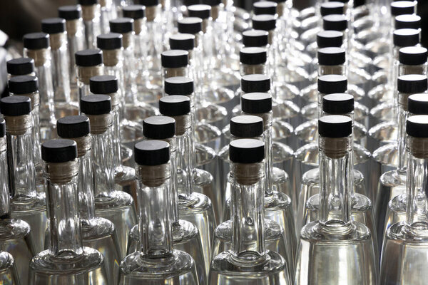 Ряды пустых прозрачных стеклянных бутылок ярко подсвеченных