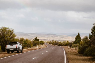 Avustralya taşrasındaki boş yolun yanındaki off-road aracı