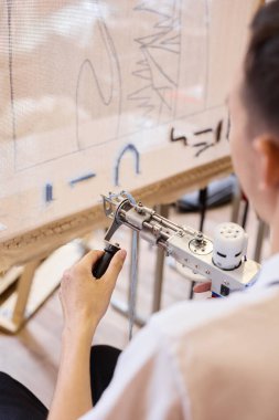 Karmaşık tasarımlar yaratmak için bir araç kullanan yenilikçi sanatçı