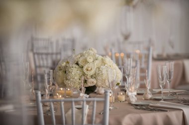 Fildişi çiçekli zarif düğün masası süslemesi