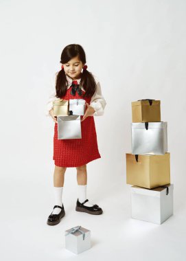 Kırmızı elbiseli bir hediye kutusu tutan neşeli kız.