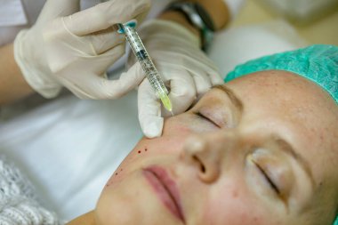 Bir kadının yüzüne botoks yapmak.