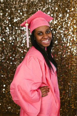 Gülümseyen ve mutlu genç mezuniyet. Siyah kız kep ve cüppeli.