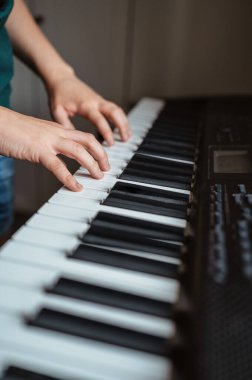 Çocuk evde oynuyor ve sentezleyici öğreniyor