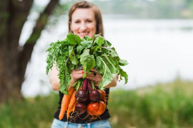 Kameraya doğru taze sebzeler tutuluyor.