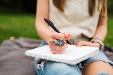 Turkuaz beyan yüzüğüyle el yazısını deftere kapat