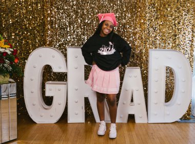 GRAD işareti olan siyah mutlu genç kızın mezuniyet portresi.