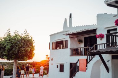 Binibeca, Menorca 'da Beyaz Yıkanmış Evlerin Yanındaki Günbatımını İzleyen İnsanlar